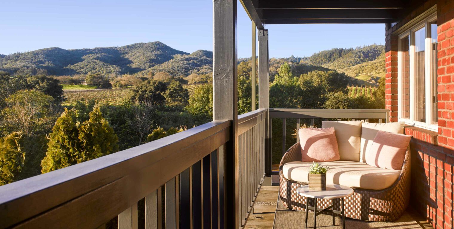 love seat on a balcony overlooking the napa valley.