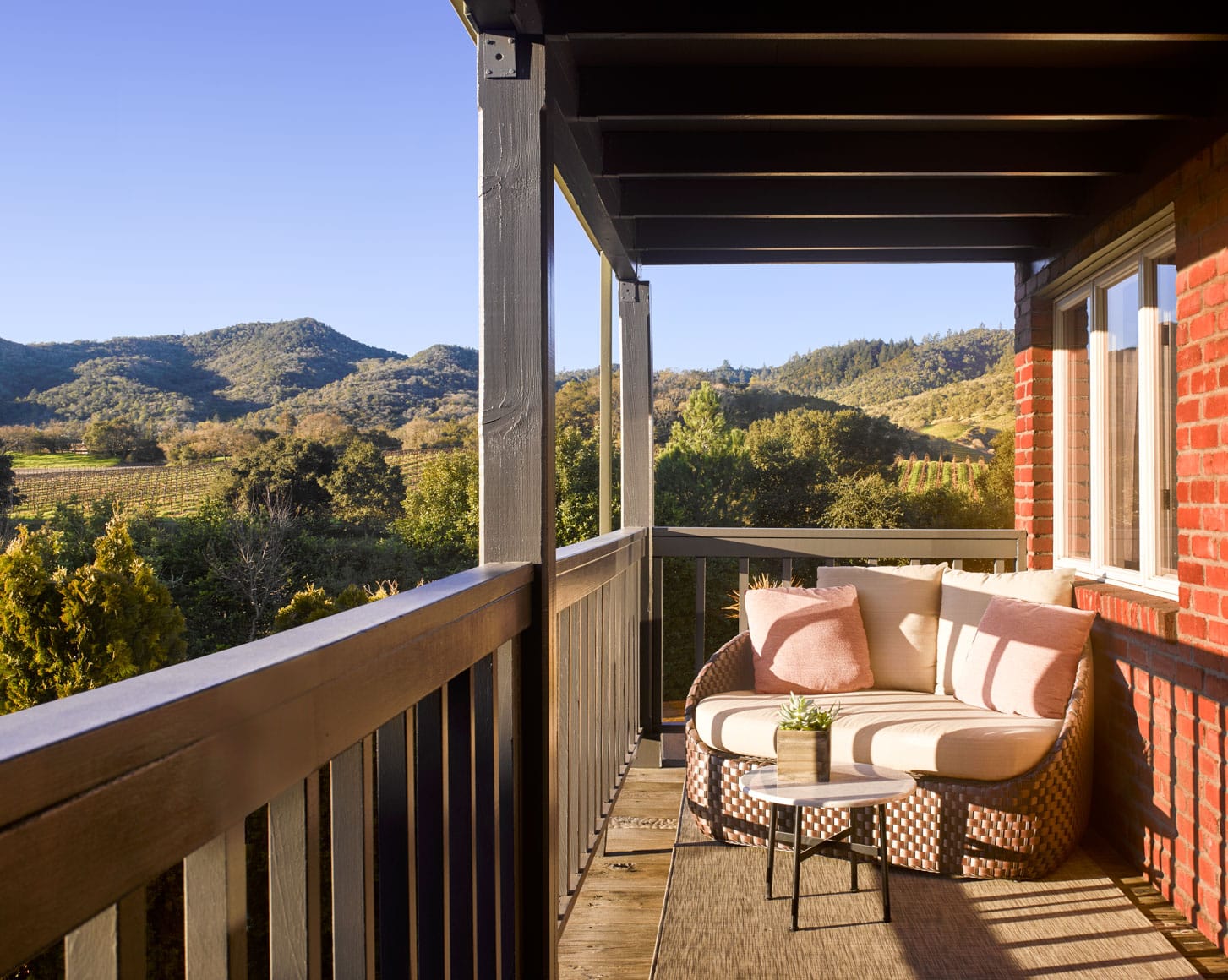 love seat on a balcony overlooking the napa valley.